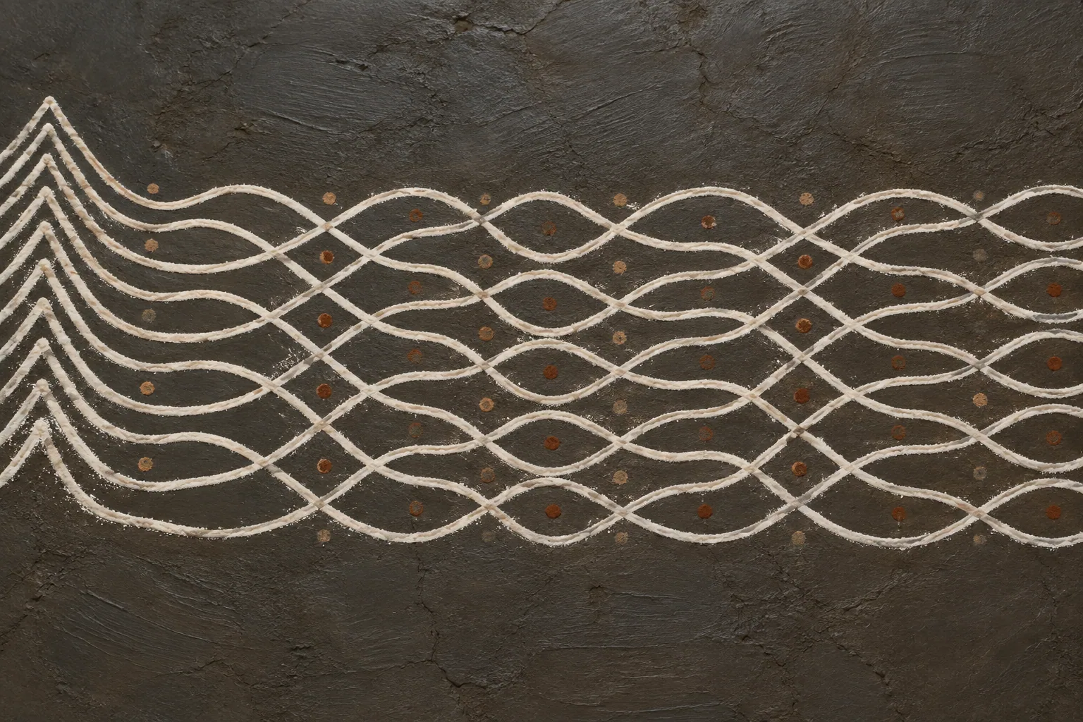 Seven white lines looping forwards and back across dark clay, braiding into a long pattern that starts at a cluster of drawn peaks.