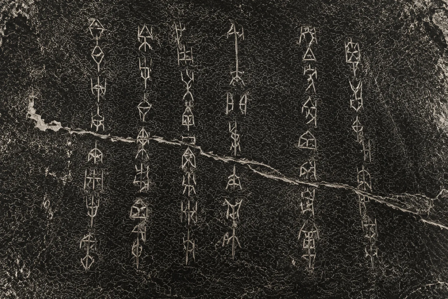 A close view of an inscribed ox scapula filling the frame, with columns of angular incised characters and one long fissure running across them.